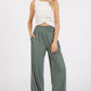 Woman wearing Mittoshop stretch banded waist wide leg pants with pockets, paired with a white top, showcasing a stylish and comfortable outfit.