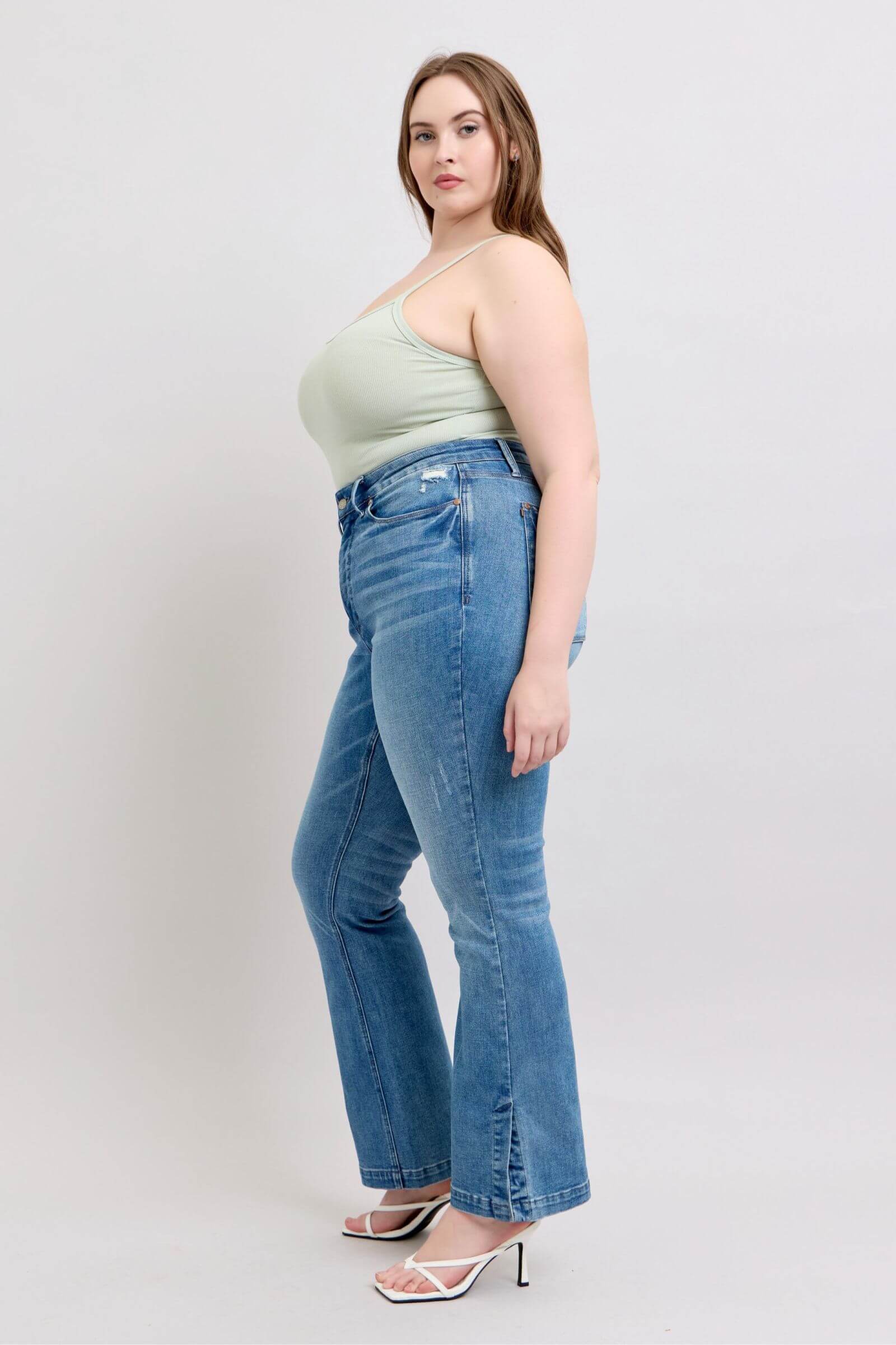 Model showcasing Judy Blue high waist tummy control vintage wash slim boot jeans with side slit detail.