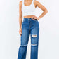 High Waist Distressed Wide Leg Jeans with ripped knees and button waist, non-stretch denim, worn by model in white crop top.