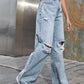 Stylish woman wearing Bella Road Distressed Wide Leg Jeans with Pockets and sneakers, showcasing unique distressed denim design.