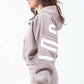 Model showcasing the American Bazi 'Los Angeles' cropped hoodie in beige with graphic detail and drawstring design.