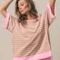 Woman wearing Exposed Seam Stripe Contrast T-Shirt with pink contrasting stripes and seam details, paired with distressed shorts.