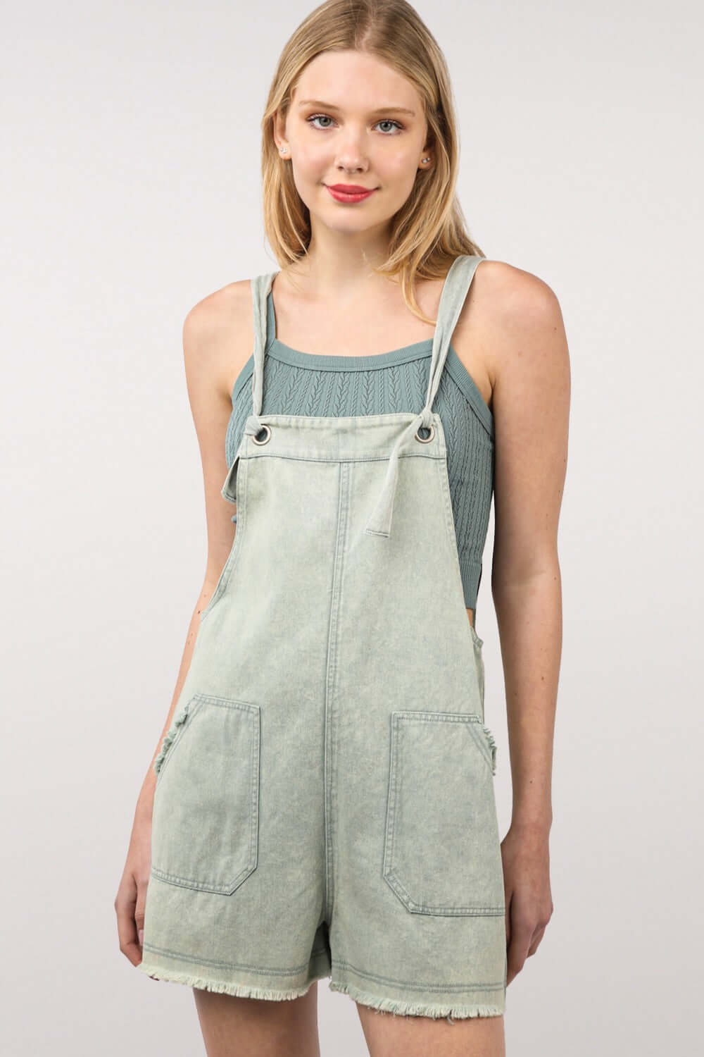 Woman wearing trendy washed frayed hem denim overall romper with side and back pockets, perfect for casual outings and vintage fashion lovers