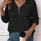 Woman wearing a Striped Half Zip Long Sleeve T-Shirt in black paired with jeans, holding a coffee cup.