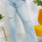 High-waisted Allie 90's Dad Jeans with light wash, distressed details, and raw hem styled with a casual street look.