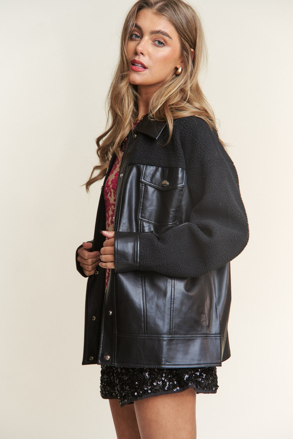 Trendy faux leather sherpa contrast jacket with snap buttons, combining sleek style and cozy warmth for versatile fashion.