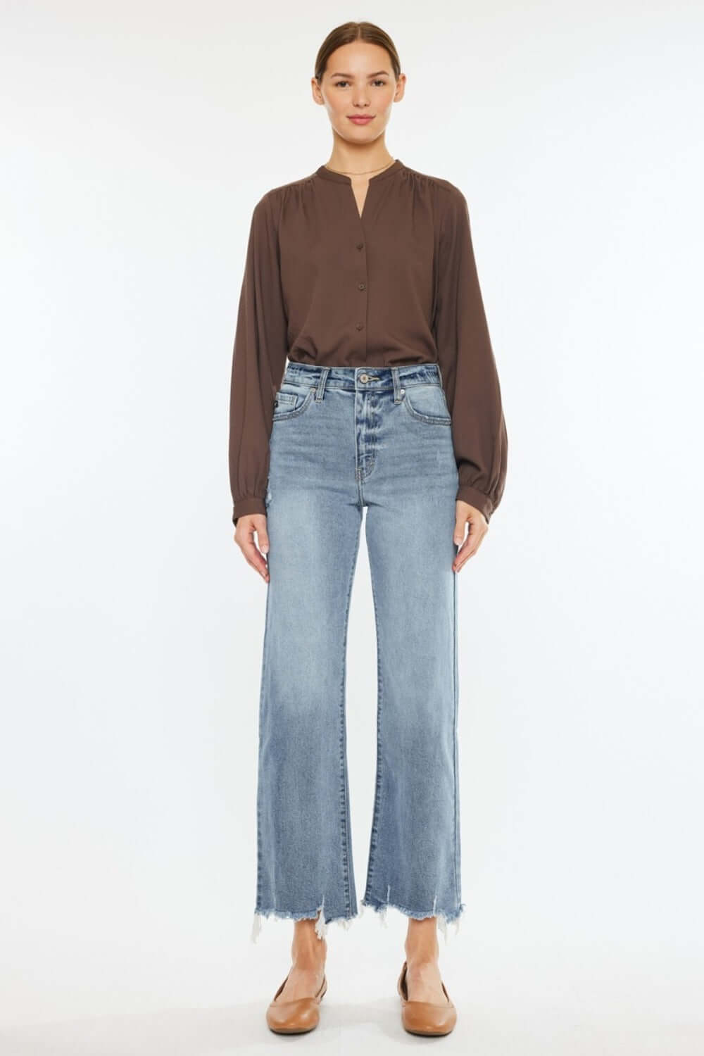 Woman wearing Kancan high-rise slim wide leg jeans in light wash with a brown blouse, showcasing modern style and comfort.