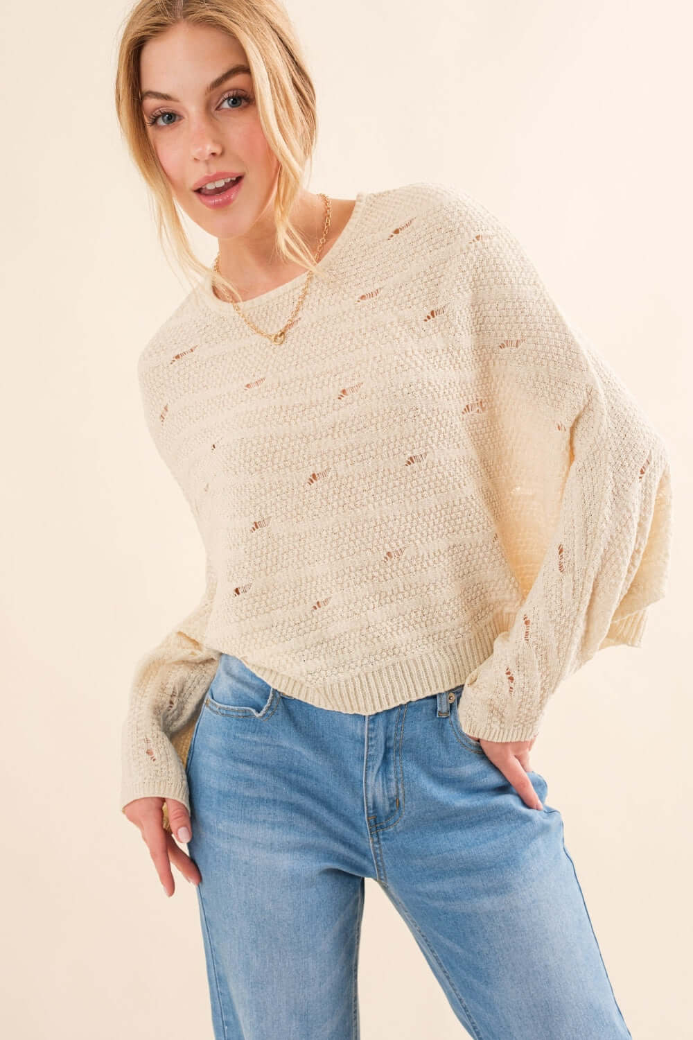 Woman wearing cozy Dolman Sleeves Sweater paired with blue jeans, showcasing relaxed fit and stylish design, perfect for cooler months.