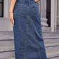 Woman wearing Bella Road Slit Midi Denim Skirt with Pockets, showcasing back slit and pocket design, perfect for a stylish look.