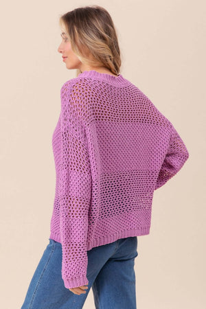 Side view of woman wearing BiBi Openwork Long Sleeve Knit Top in purple, showcasing intricate details, paired with blue jeans.