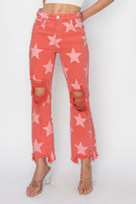 Distressed Raw Hem Star Pattern Risen Jeans in coral with ripped knees and frayed cuffs, showcasing bold, stylish rock 'n' roll fashion.