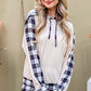 Stylish woman in drawstring hooded top and plaid pants, showcasing cozy lounge set for trendy comfort.