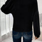 Rear view of woman wearing Bella Road Ribbed Round Neck Lantern Sleeve T-Shirt in black with jeans, standing by a window.