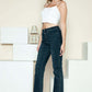 Woman wearing Judy Blue Full Size Button Fly Hem Destroy Straight Jeans with a white crop top and heels.