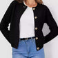 Woman in Bella Road Button Up Round Neck Long Sleeve Cardigan in black with trendy button-up design, paired with white top and blue jeans.