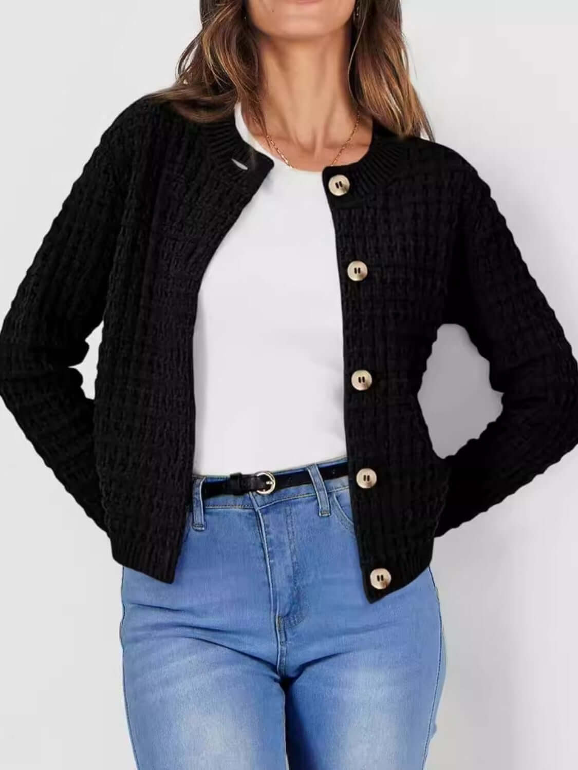 Woman in Bella Road Button Up Round Neck Long Sleeve Cardigan in black with trendy button-up design, paired with white top and blue jeans.