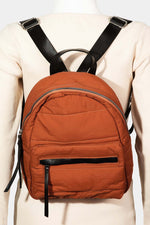 Adjusted back view of a stylish orange nylon backpack with black straps, perfect for everyday use or travel.