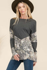 Woman wearing Celeste mixed animal print contrast long sleeve t-shirt with v-shaped design, paired with jeans and stylish wide-brim hat.