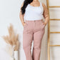 Curve model wearing High Rise Ankle Flare Jeans by Risen Jeans in a minimalistic setting.