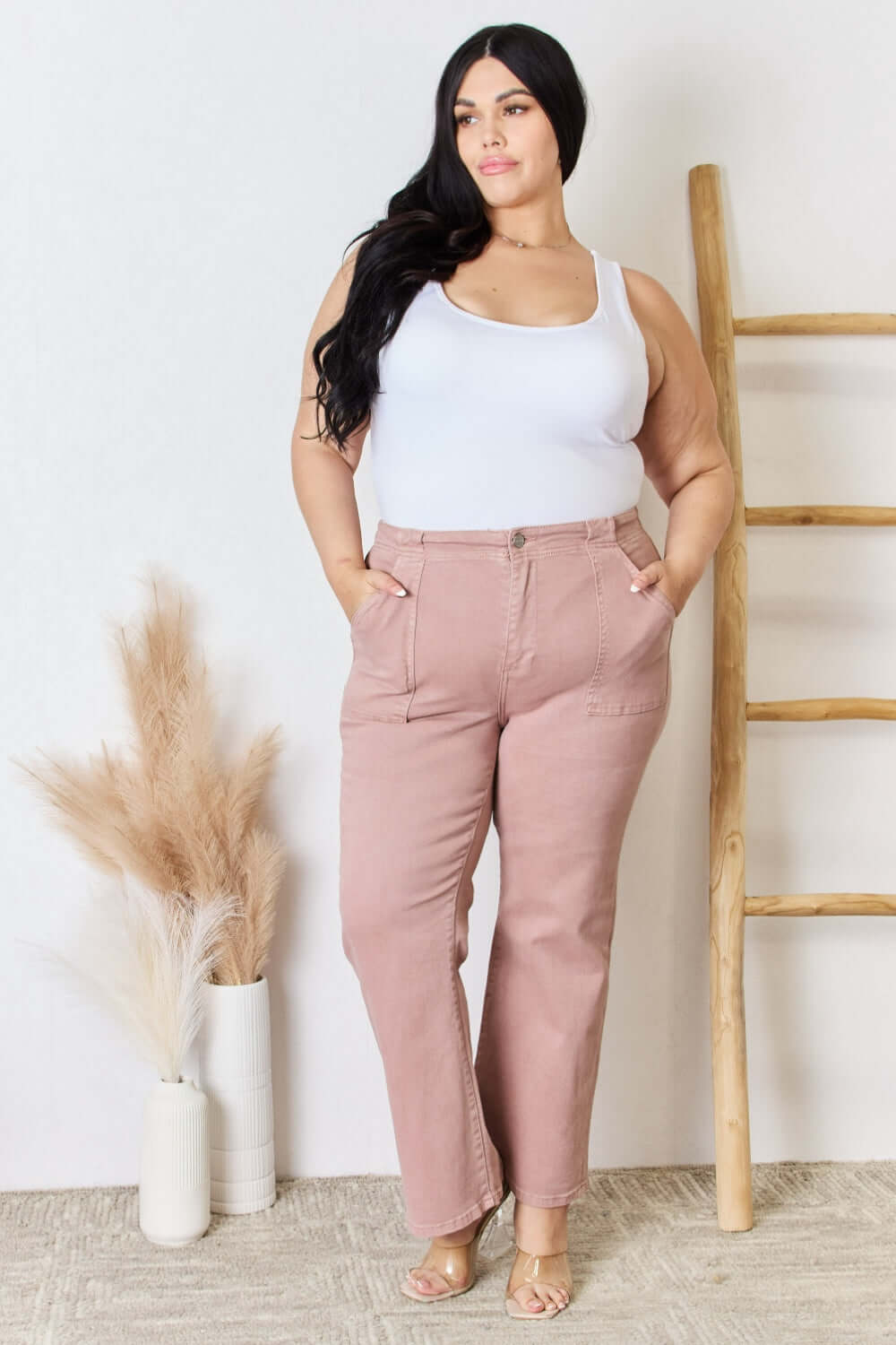 Curve model wearing High Rise Ankle Flare Jeans by Risen Jeans in a minimalistic setting.