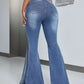 Woman wearing slit flare jeans with pockets standing in a stylish indoor setting.