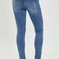 Woman wearing mid rise ankle skinny jeans with a comfortable fit and trendy ankle length, highlighting the sleek Risen Jeans design.