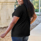 Smiling woman wearing a black Basic Bae Bamboo V-Neck Short Sleeve T-Shirt in casual outdoor setting.