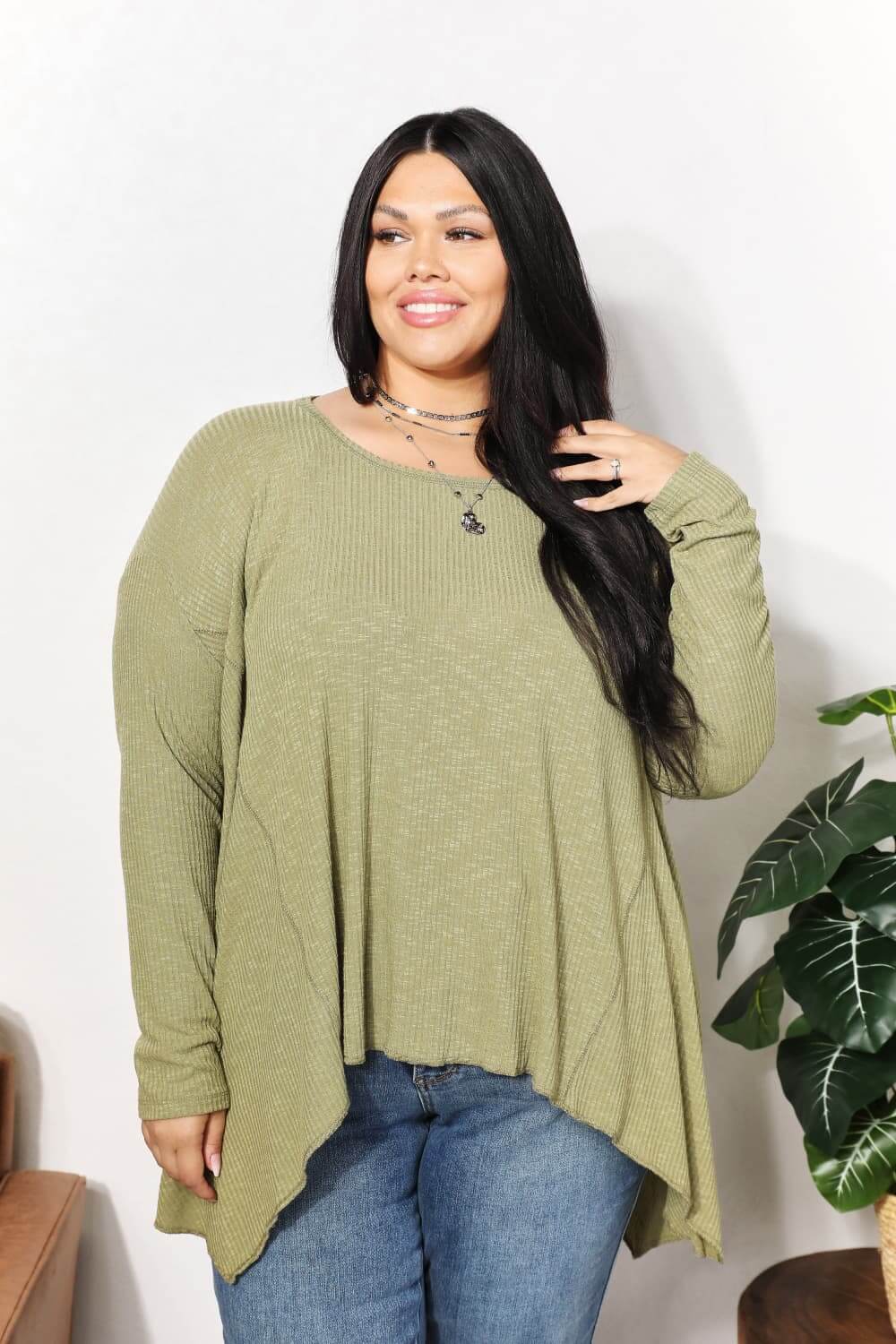 Woman wearing an oversized super soft rib layering top with a round neck and sharkbite hem in green