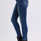 Side view of Judy Blue mid-rise skinny jeans in blue with pockets, styled with chic black ankle boots.