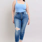 Model in blue bodysuit showcasing Judy Blue plus size button fly distressed jeans with pockets.