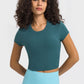 Millennia cropped sports t-shirt in teal, featuring a round neck and short sleeves, perfect for yoga and workouts.