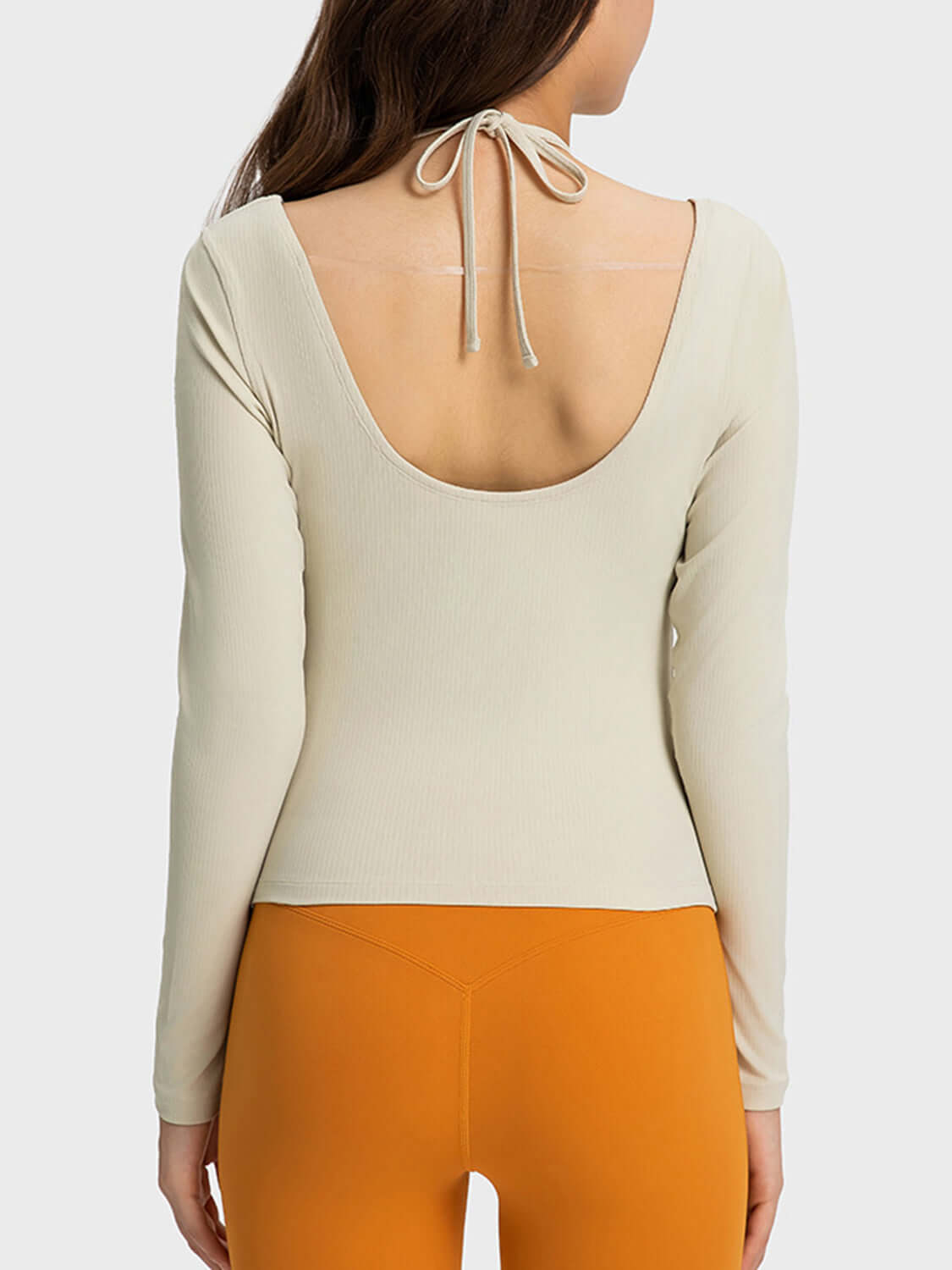 Back view of Millennia Halter Neck Long Sleeve Sporty Top paired with orange leggings, showcasing stylish design and comfort.