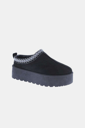 Black platform slip-on boot with embroidered trim and chunky sole for stylish comfort.