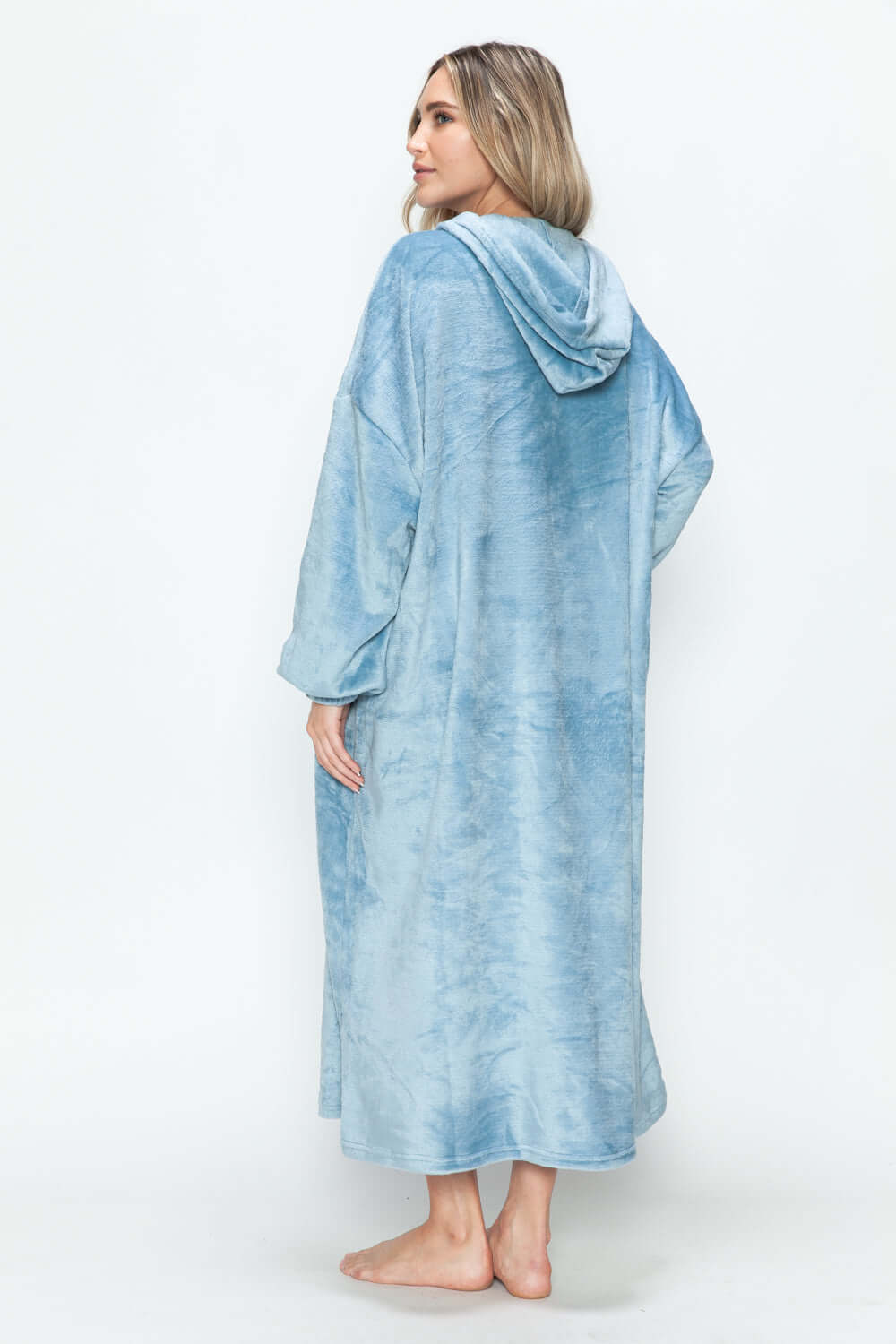 Woman wearing a cozy blue hooded midi dress, showcasing its back and relaxed style, perfect for lounging.