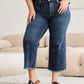 Woman wearing RFM Jeans Tummy Control High Waist Raw Hem Distressed Jeans in a living room setting.