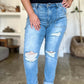 Woman wearing Judy Blue distressed straight jeans with patch pockets, showcasing trendy ripped detailing and high waist design.