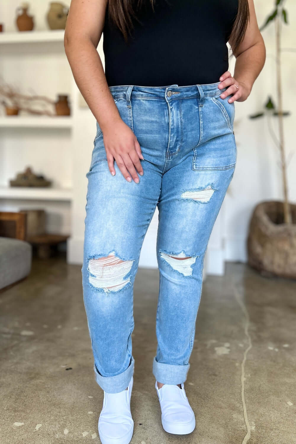 Woman wearing Judy Blue distressed straight jeans with patch pockets, showcasing trendy ripped detailing and high waist design.