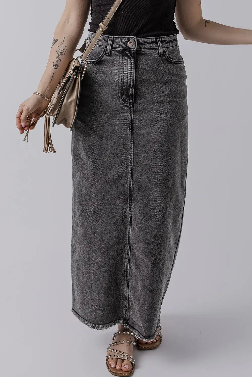 Woman wearing Bella Road Raw Hem Midi Denim Skirt with pockets, showcasing edgy style and comfort for any adventure.