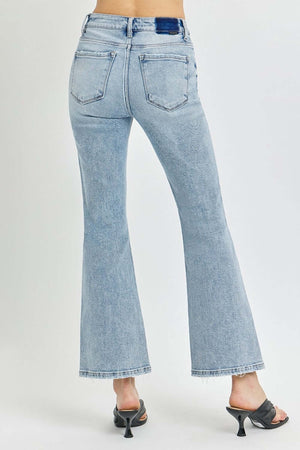 Rear view of model wearing RISEN Full Size High Rise Ankle Flare Jeans in light wash, showcasing trendy flared hem and high-waisted fit.