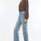 Model wearing Kancan high-rise slim wide leg jeans in light wash with unique hem details, perfect for versatile styling.