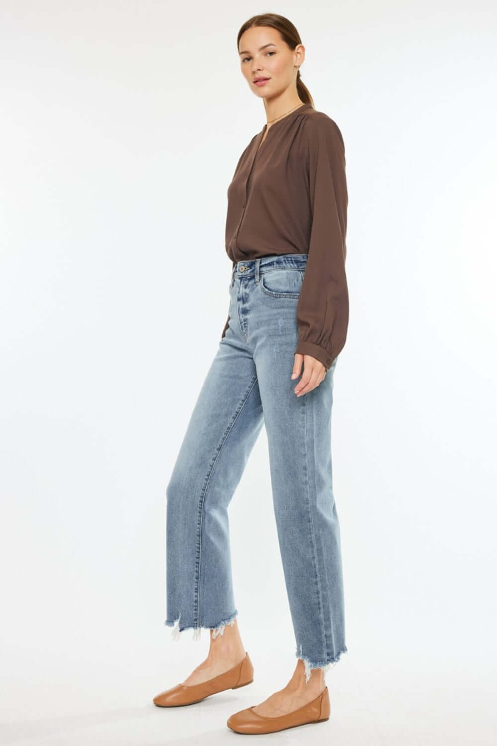 Model wearing Kancan high-rise slim wide leg jeans in light wash with unique hem details, perfect for versatile styling.