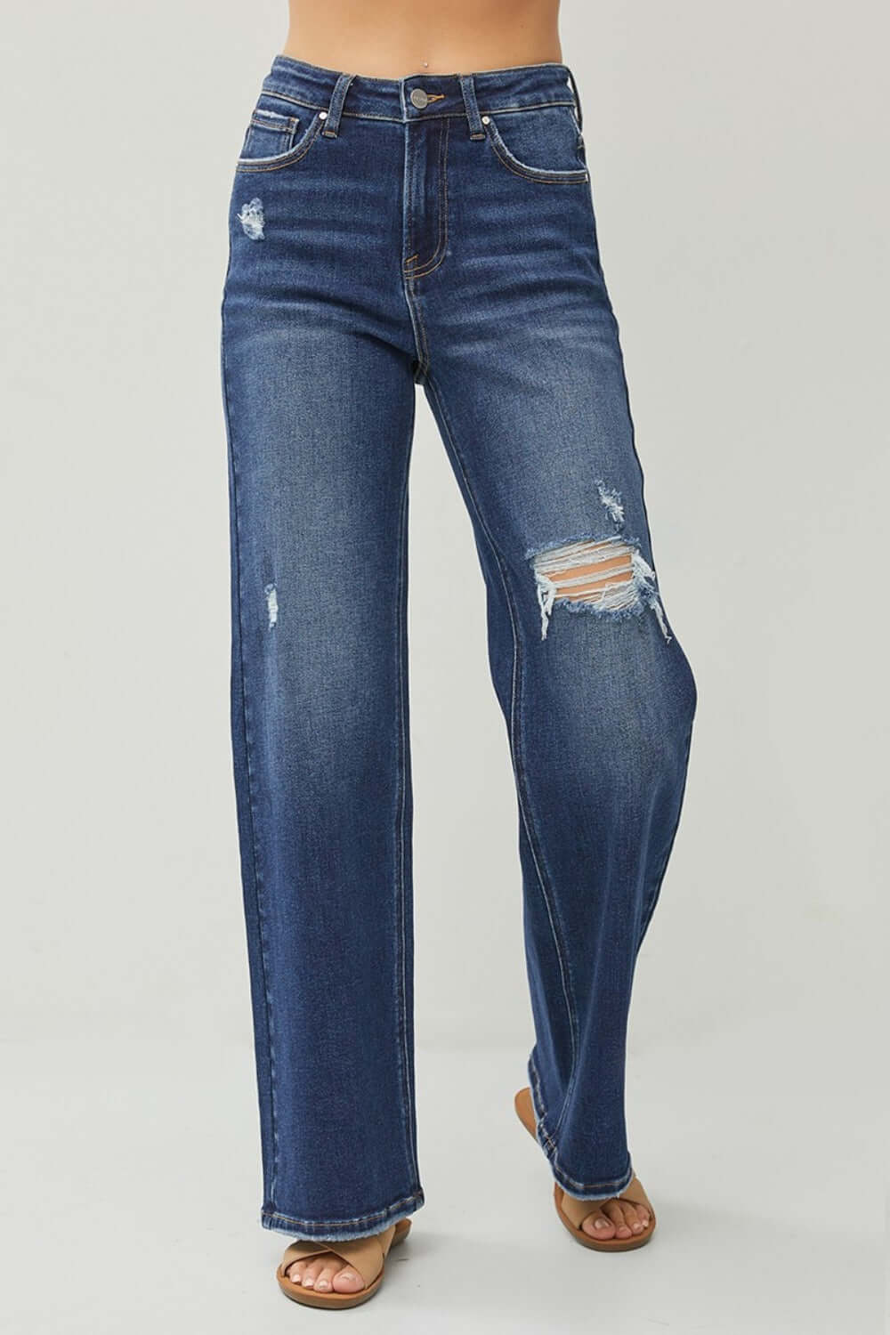 High rise distressed wide leg jeans with pockets and slight stretch, showcasing a trendy and casual streetwear-inspired design.