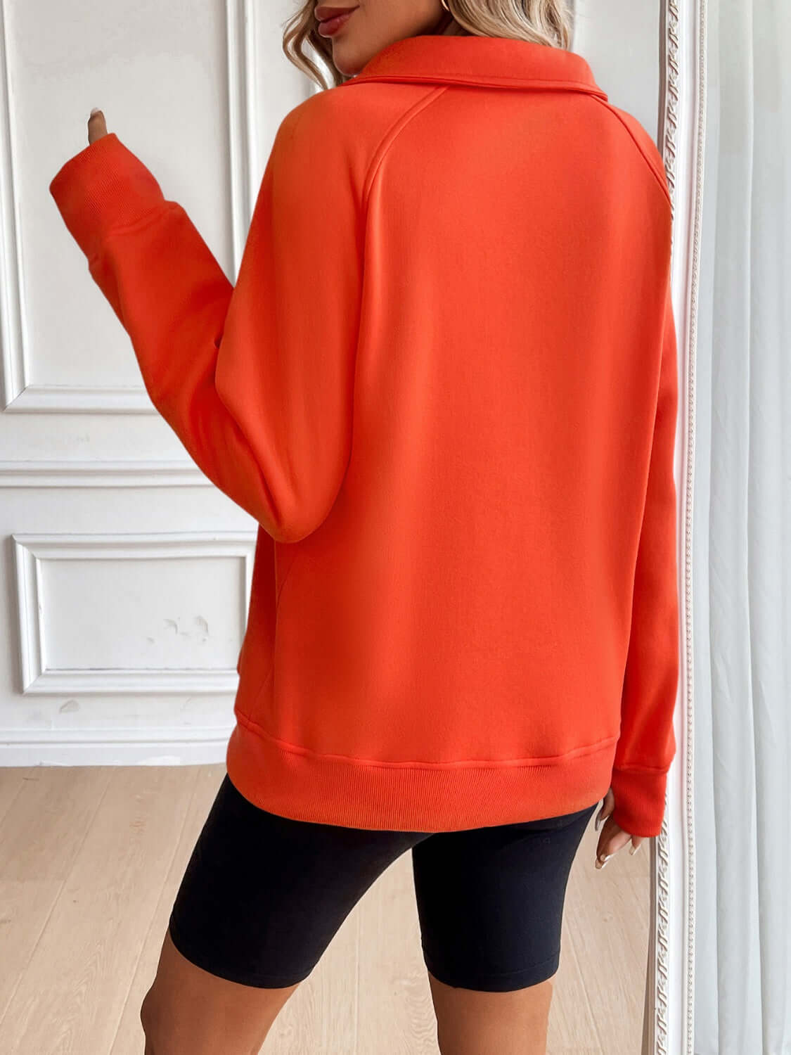 Back view of Ivy Lane Half Zip Raglan Sleeve Sweatshirt in vibrant orange, featuring a comfortable fit and stylish design.