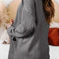 Woman wearing a grey textured open-front cover-up with pockets, featuring a slightly stretchy material, perfect for casual occasions.