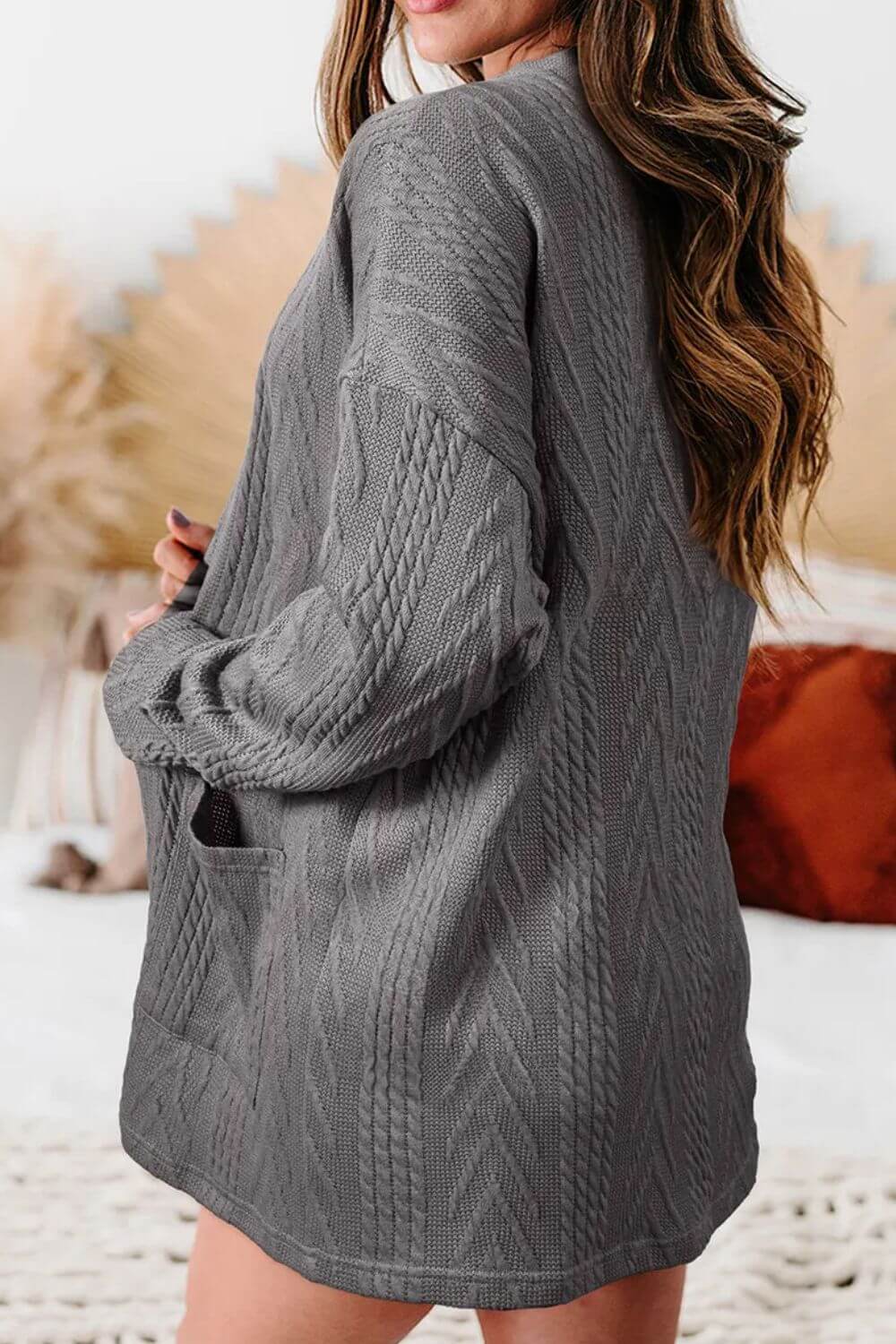 Woman wearing a grey textured open-front cover-up with pockets, featuring a slightly stretchy material, perfect for casual occasions.