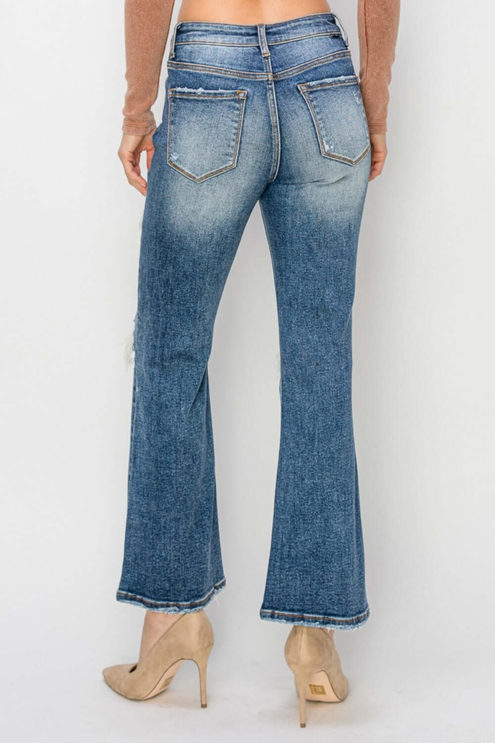 Back view of high-rise distressed ankle flare jeans by Risen Jeans, featuring stylish distressed details and a chic petite fit.