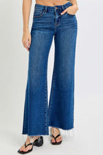 High rise wide leg jeans with tummy control, featuring a chic design and convenient pockets, paired with flip-flops for a casual look.