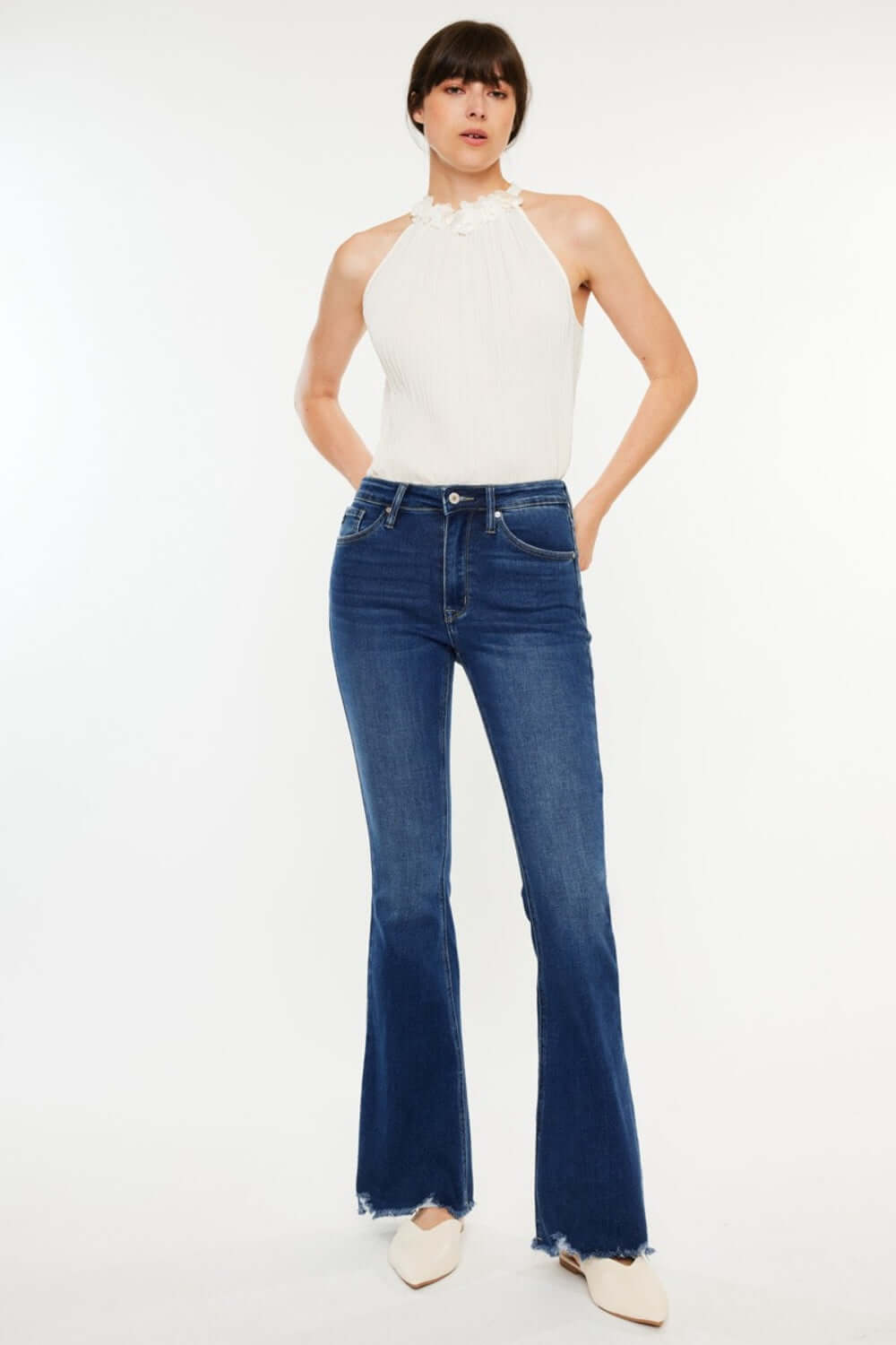 Fashion-forward woman wearing Cat's Whiskers Raw Hem Flare Jeans with edgy sophistication and retro vibes. Versatile, stylish fashion essential.