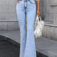 Light wash bootcut jeans with pearl trim, styled casually with a crop top and white handbag. Perfect for chic outings!