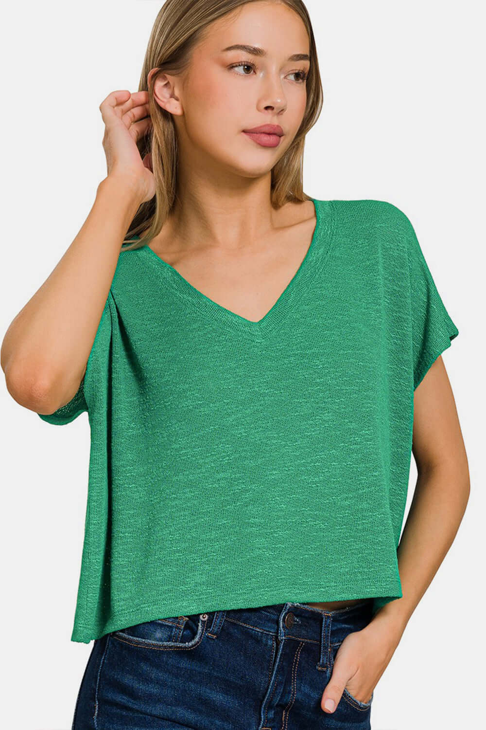 Woman wearing a green V-neck short sleeve t-shirt paired with blue jeans. Perfect for casual outings or lounging at home.